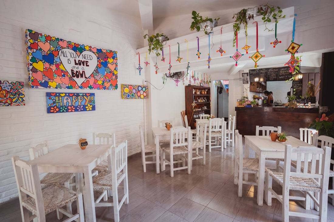 Bright and colorful cafe interior with artistic decorations and cozy seating.